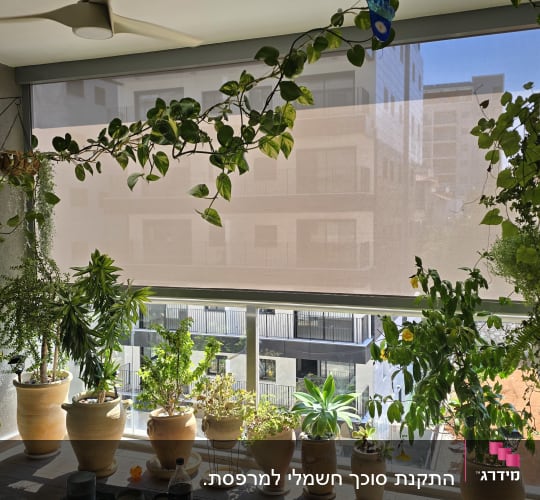סוכך מסך אנכי מותקן במרפסת שמש מעוצבת עם עציצים וצמחייה